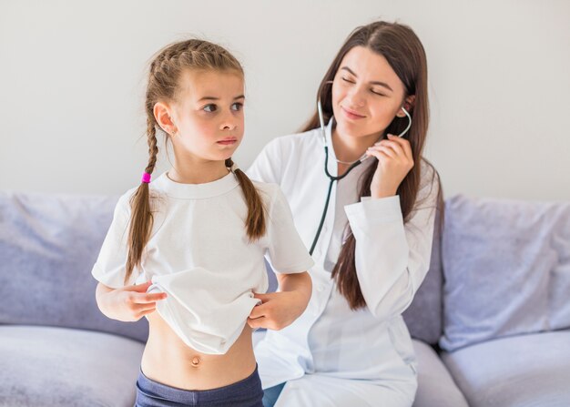 Ill girl being examined by the doctor