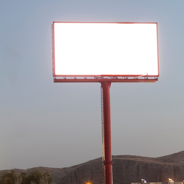 Illuminated blank billboard for advertisement against blue sky