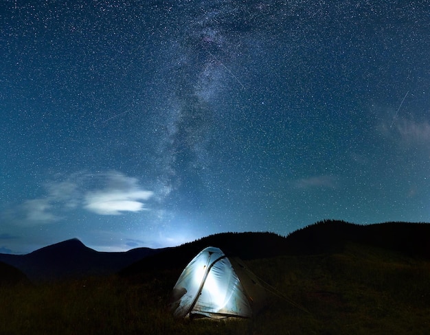 별이 있는 아름다운 밤하늘 아래 조명이 있는 캠프 텐트