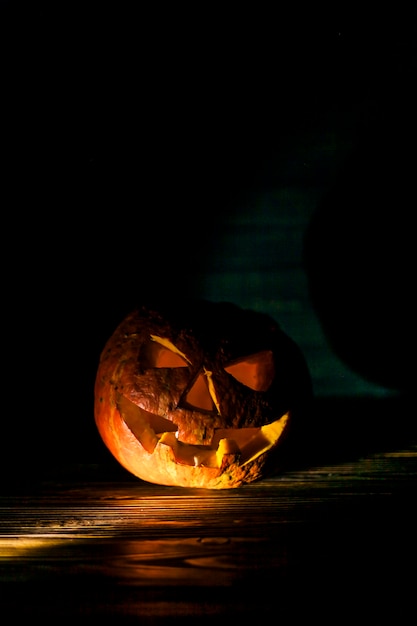 Illuminated pumpkin on wooden desk