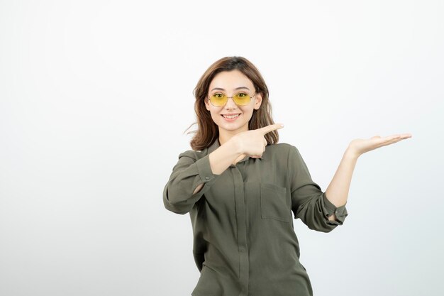 Image of adorable girl in glasses giving ok sign over white. High quality photo