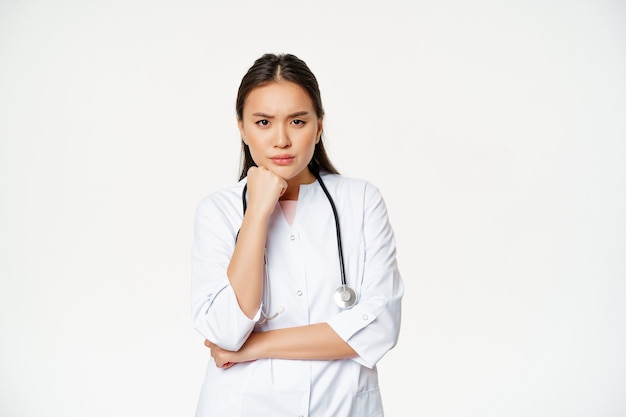 화가 난 간호사 아시아 여성 의사의 이미지는 짜증나고 짜증나는 눈썹 눈썹과 찡그린 표정을 하고 있습니다.