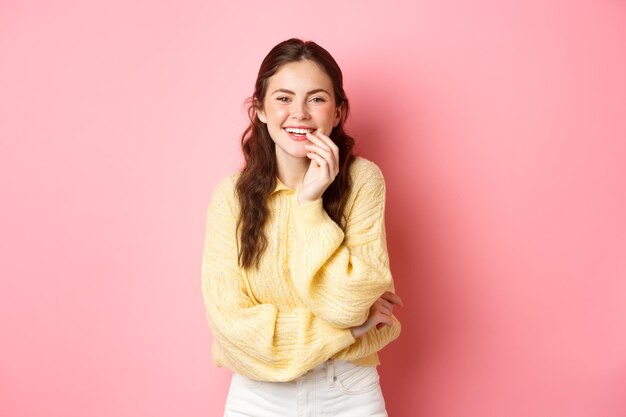 Image of attractive young woman laughing looking at camera something funny standing cheerful against...