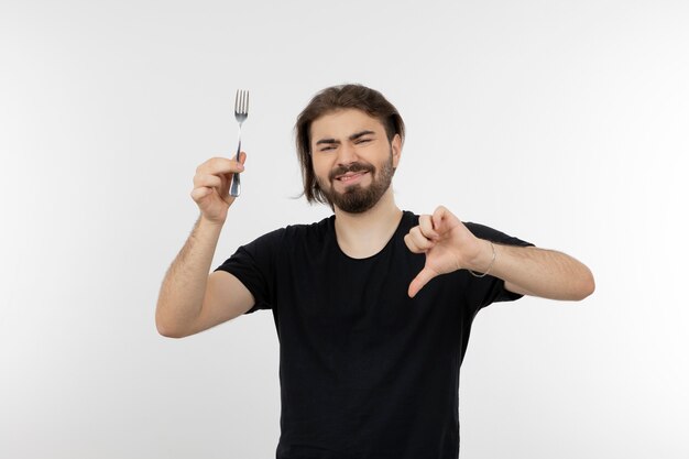 Image of bearded man holding fork and showing thumb down.