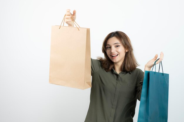 Image of beautiful short-haired girl holding shopping bags. High quality photo