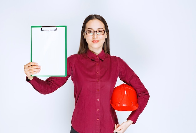 Foto gratuita immagine di una bella donna con gli occhiali che tiene il casco con cartella.