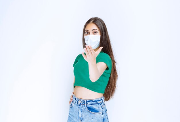 Image of beautiful young girl in medical mask looking at camera and posing. 