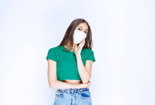 Image of beautiful young woman in medical mask looking at camera.