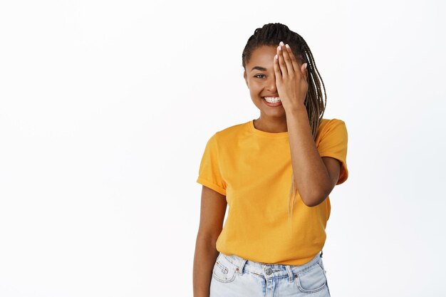 Image of Black girl with natural clean skin no makeup cover half of face before and after skincare concept white background