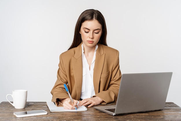 책상에 앉아 노트북으로 문서를 작성하는 사무실에서 일하는 여성 사업가의 이미지