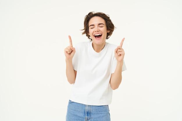 Free Stock Photos: Image of Carefree Girl Laughing and Smiling Pointing Fingers Up Showing Promo Offer Banner on Top