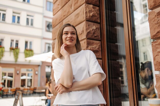 Image of cheerful woman in city look away