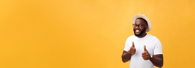 Image of cheerful young african man standing and posing over yellow background with thumbs up lookin