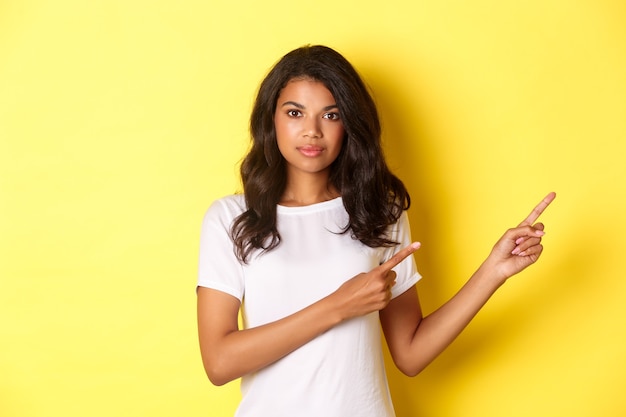 Image of confident and attractive africanamerican woman pointing fingers right