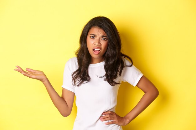 Image of confused and annoyed africanamerican girl having an argument raising hand