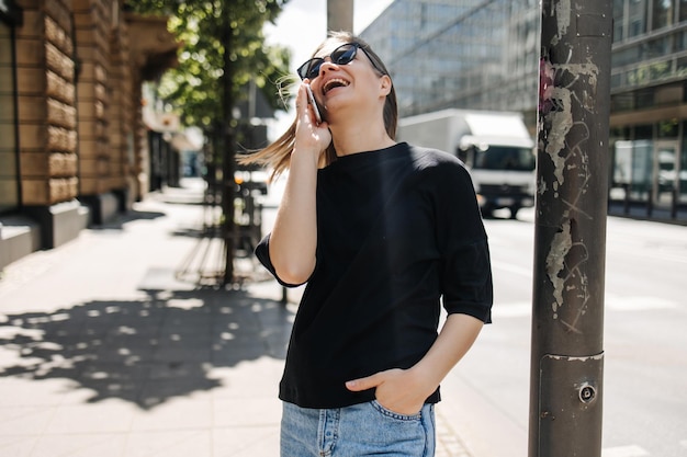 Image of cute woman luffing with phone in the city