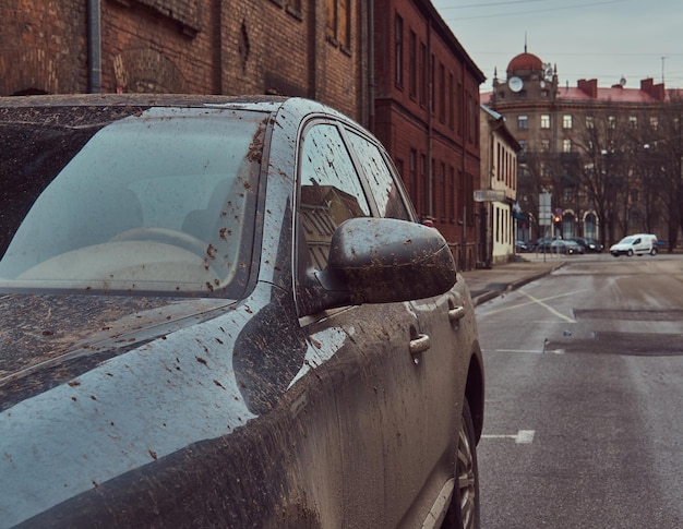 Image of a dirty car after a trip off-road. Stands against a brick wall in the old part of town.