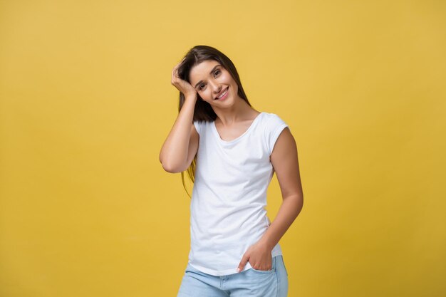 Image of excited young woman standing isolated over yellow background Looking camera