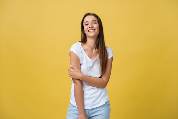 Image of excited young woman standing isolated over yellow background. Looking camera.
