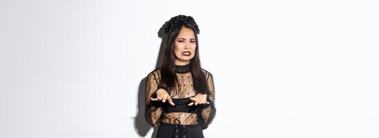 Image of funny asian woman in halloween witch costume looking disgusted refuse from something nasty