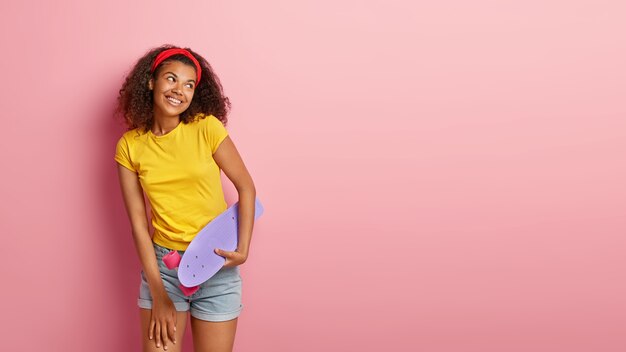 Image of happy lovely teenage girl with curly hair posing in yellow tshirt