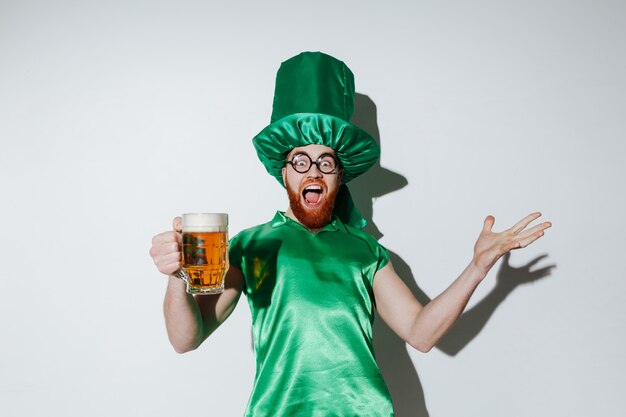 ビールを保持しているst.patriks衣装で幸せな男のイメージ