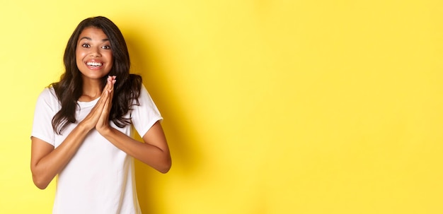 Free photo image of happy and pleased africanamerican girl clap hands and looking excited thanking for somethin