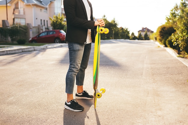 Image of a man with longboard going on road