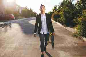 Free photo image of a man with longboard going on road