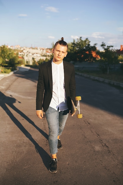 Image of a man with longboard going on road