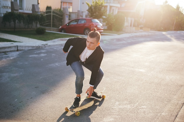 道路に行くロングボードを持つ男の画像