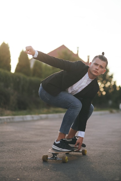 Image of a man with longboard going on road