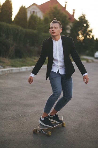 Image of a man with longboard going on road