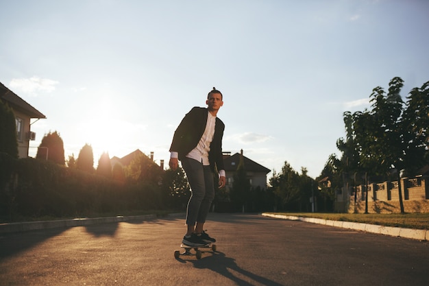 Image of a man with longboard going on road