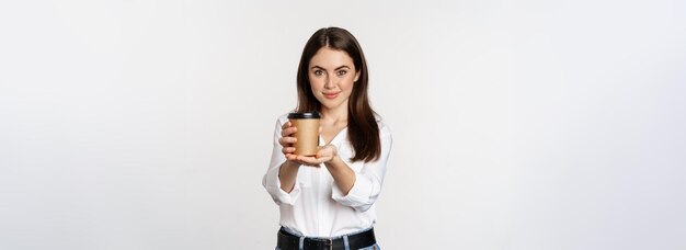 Image of modern woman office lady holding takeaway coffee cup and smiling standing over white backgr