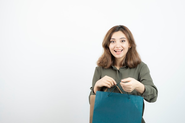 ショッピング​バッグ​が​立っている​美しい​短い​髪​の​少女​の​画像​。​高​品質​の​写真