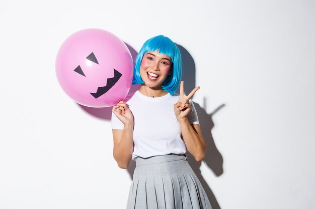 やさしい陽気でかっこいい中年女性の赤毛の白いtシャツは控えめな笑顔で左上隅を指してアドバイスを与える 無料の写真