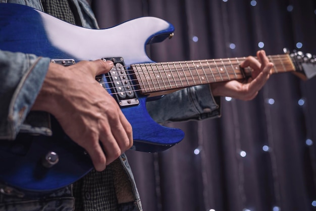 일렉트릭 기타를 연주하는 음악가의 손 이미지. 콘서트 및 엔터테인먼트 이벤트의 개념입니다. 혼합 매체