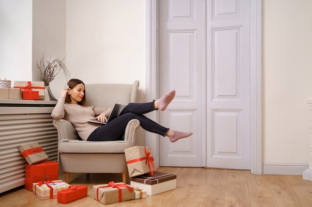 Image of pleased nice woman holding credit card with copy space using laptop