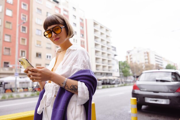 Image of pretty woman in sunglasses looking at phone