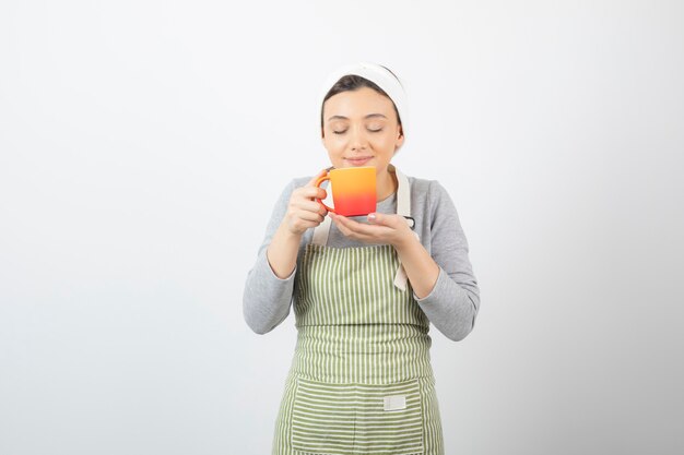 Image of a pretty young woman in apron holding a cup