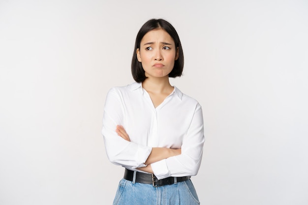 Free photo image of sad office girl asian woman sulking and frowning disappointed standing upset and distressed against white background