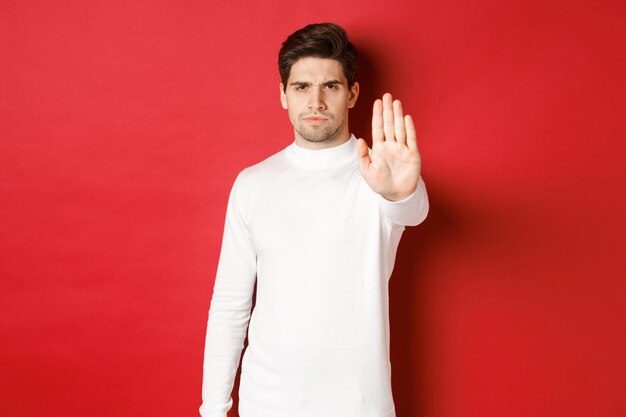 Image of serious and confident man telling to stop forbid something extending one hand and prohibit ...