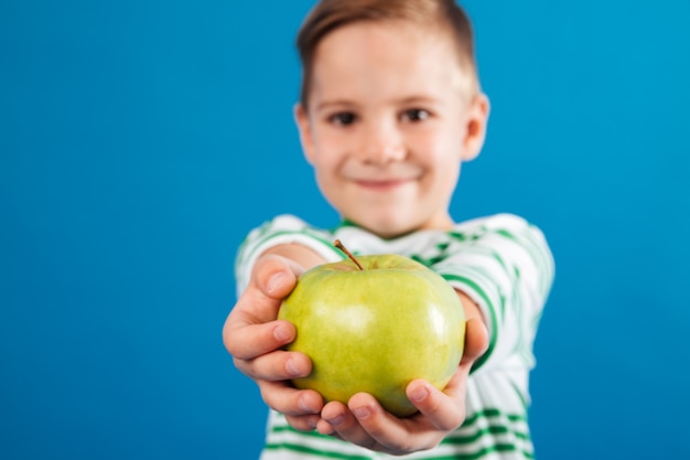 Изображение улыбающегося мальчика, давая яблоко