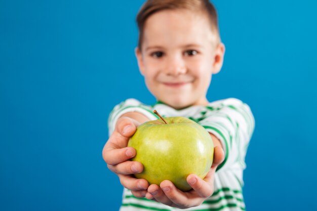 リンゴを与える笑顔の若い男の子のイメージ