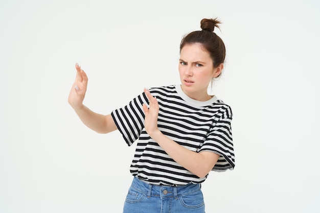 Free photo image of woman expressing aversion dislike something looks apalled extends hands forward in