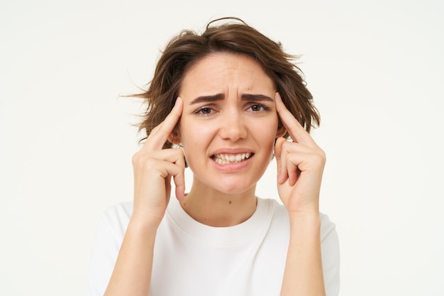 Foto gratuita immagine di una donna in preda al panico che pensa al brainstorming e si sforza di ricordare qualcosa in piedi sopra il bianco