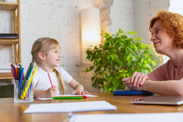 Image of woman psychologist working having session with little girl child Giving help support
