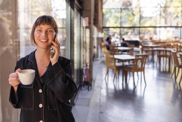 Image of woman smiling at camera with phone