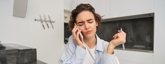 Free photo image of woman with confused face answering phone call and looking puzzled cant understand